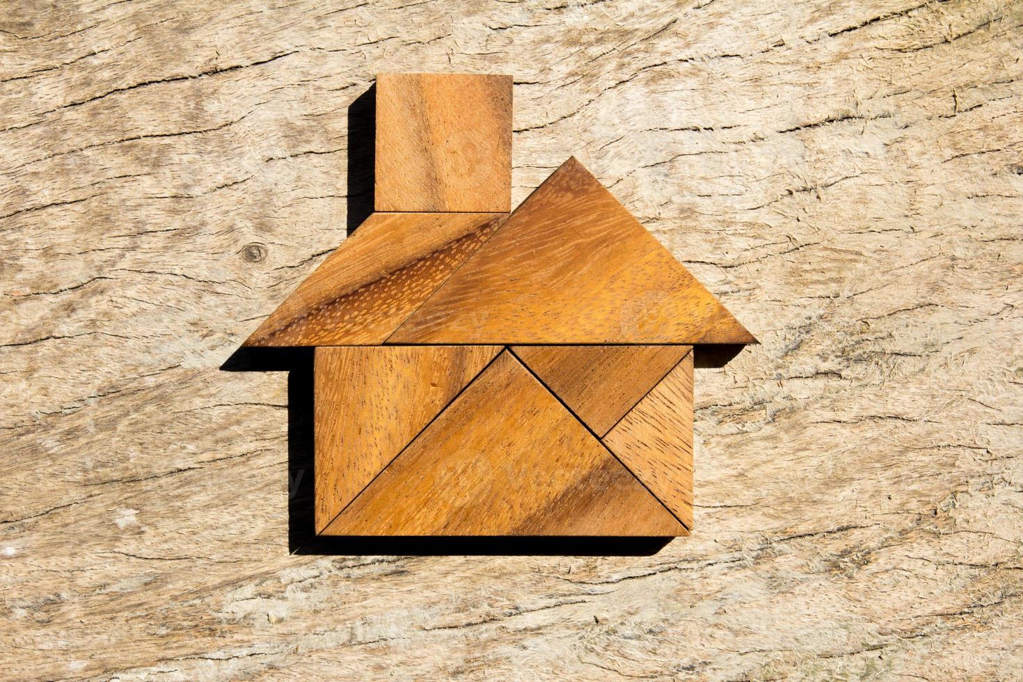 Wooden tangram puzzle in home shape for dream home or happy life concept photo