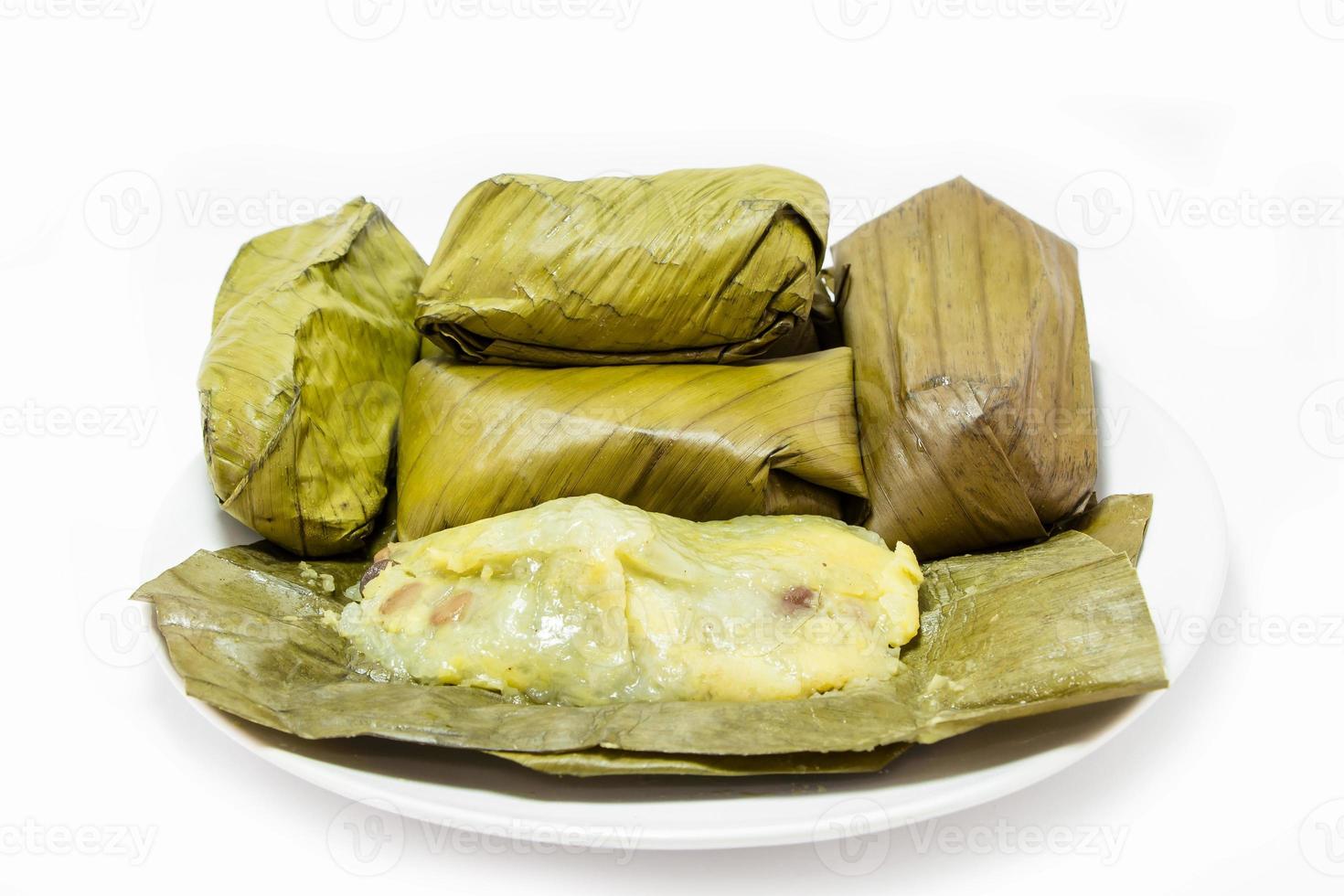 Thai dessert, steam sticky rice with custard cream wrapped with banana leaf isolated photo