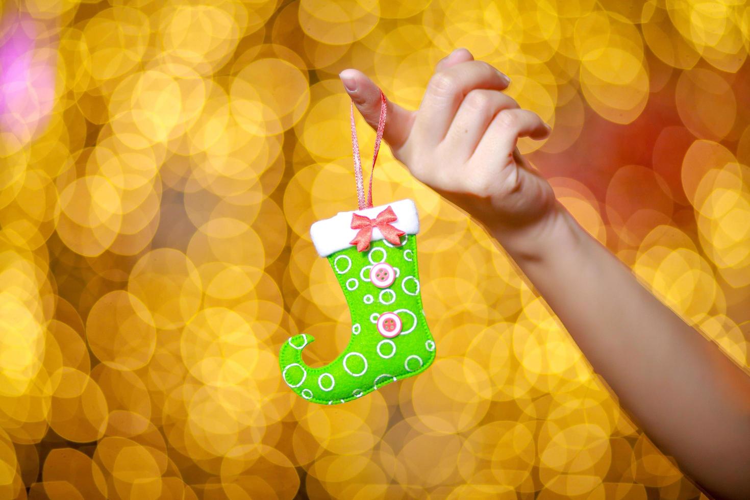 Merry Christmas and Happy New Year. Gift Christmas in woman's hands with glowing hearts bokeh. photo