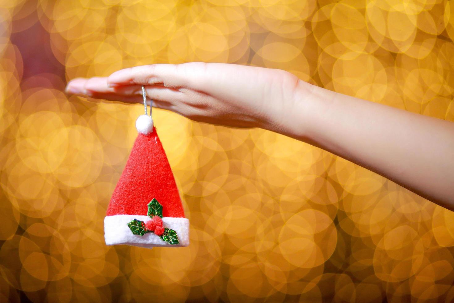 Merry Christmas and Happy New Year. Gift Christmas in woman's hands with glowing hearts bokeh. photo