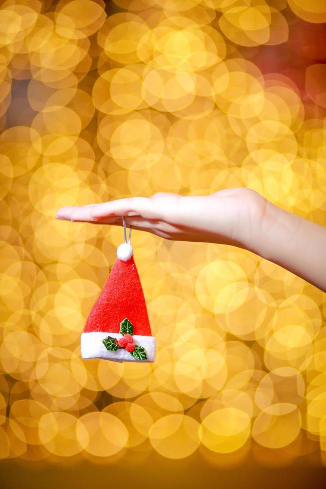 Merry Christmas and Happy New Year. Gift Christmas in woman's hands with glowing hearts bokeh. photo