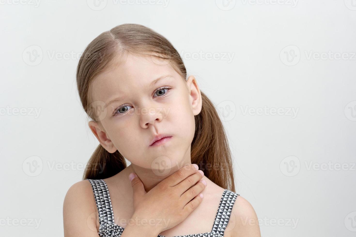 Child holding hand on throat photo