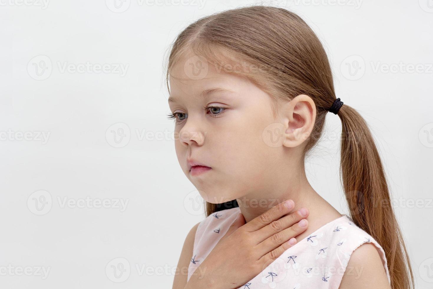 Child holding hand on throat photo