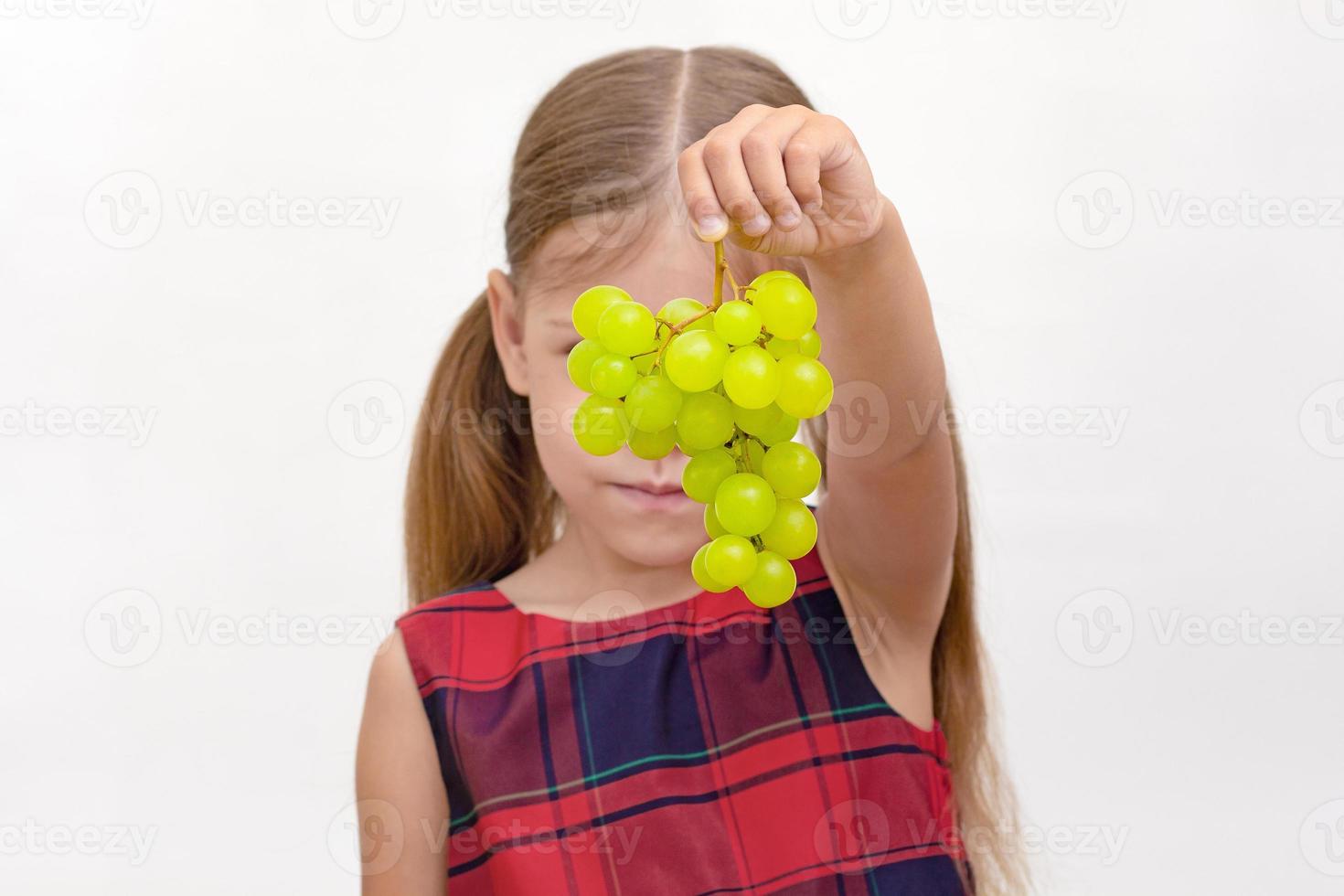 niño sosteniendo un racimo de uvas foto