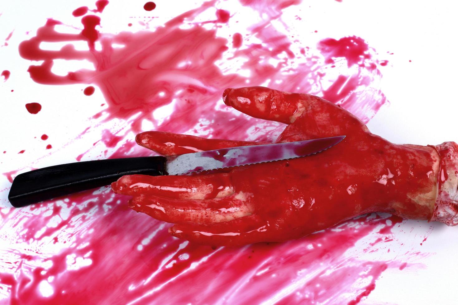 A bloody hand making a fist with blood dripping down isolated on white. photo