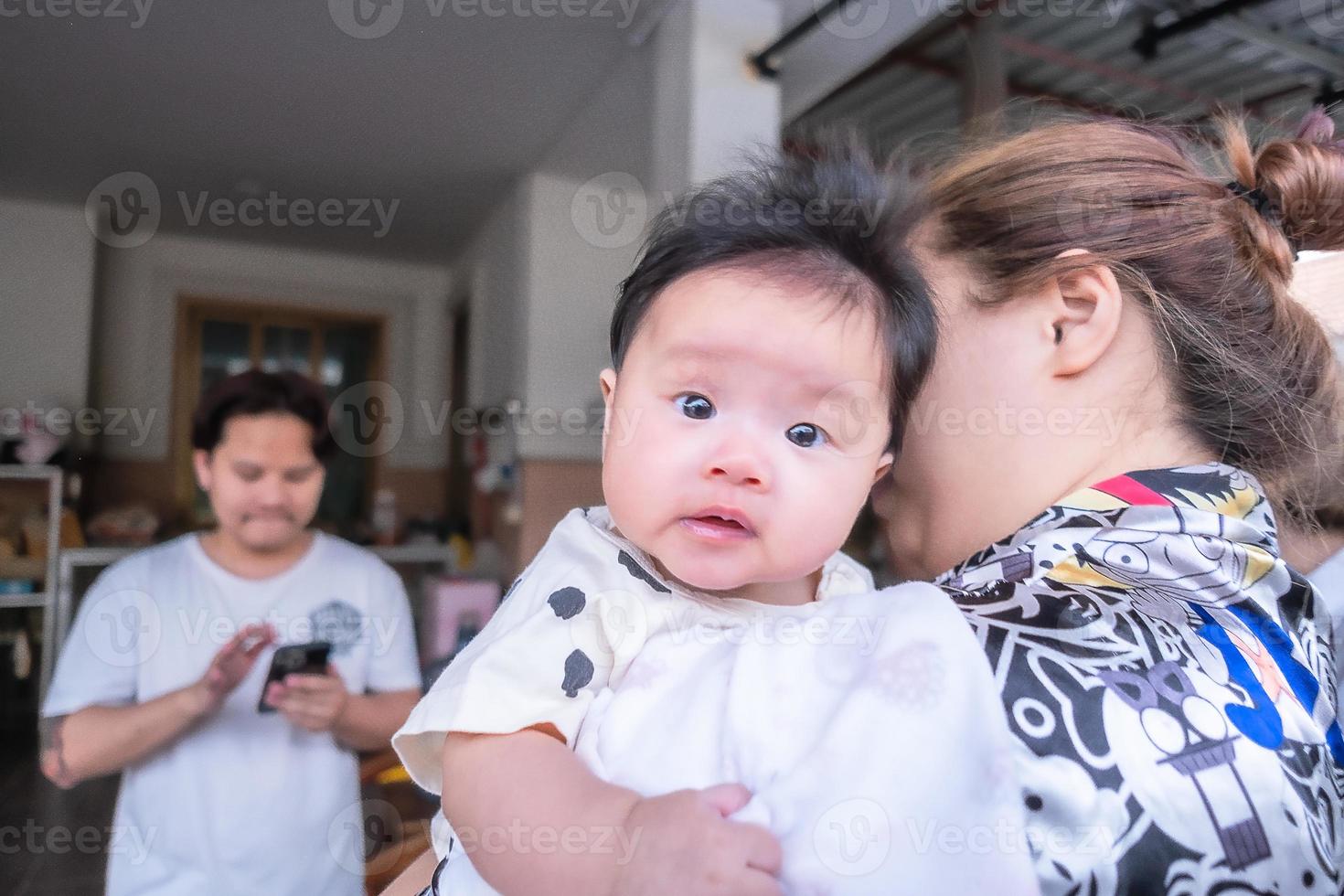 Asian newborn baby kid eye contact with mom cuteness of children with happy family on soft mattress metaphor living life healthy lifestyle cute of kid baby products health products for mother and baby photo