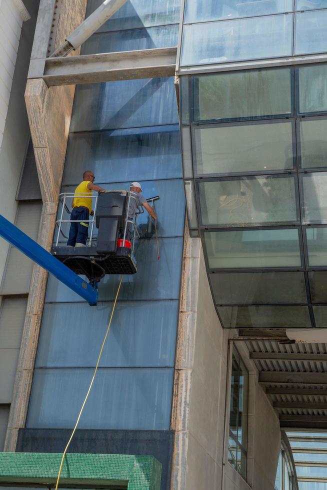 Cattolica Italy 2022 Glass cleaner in the shopping center using the mobile platform to reach the upper parts of the building photo