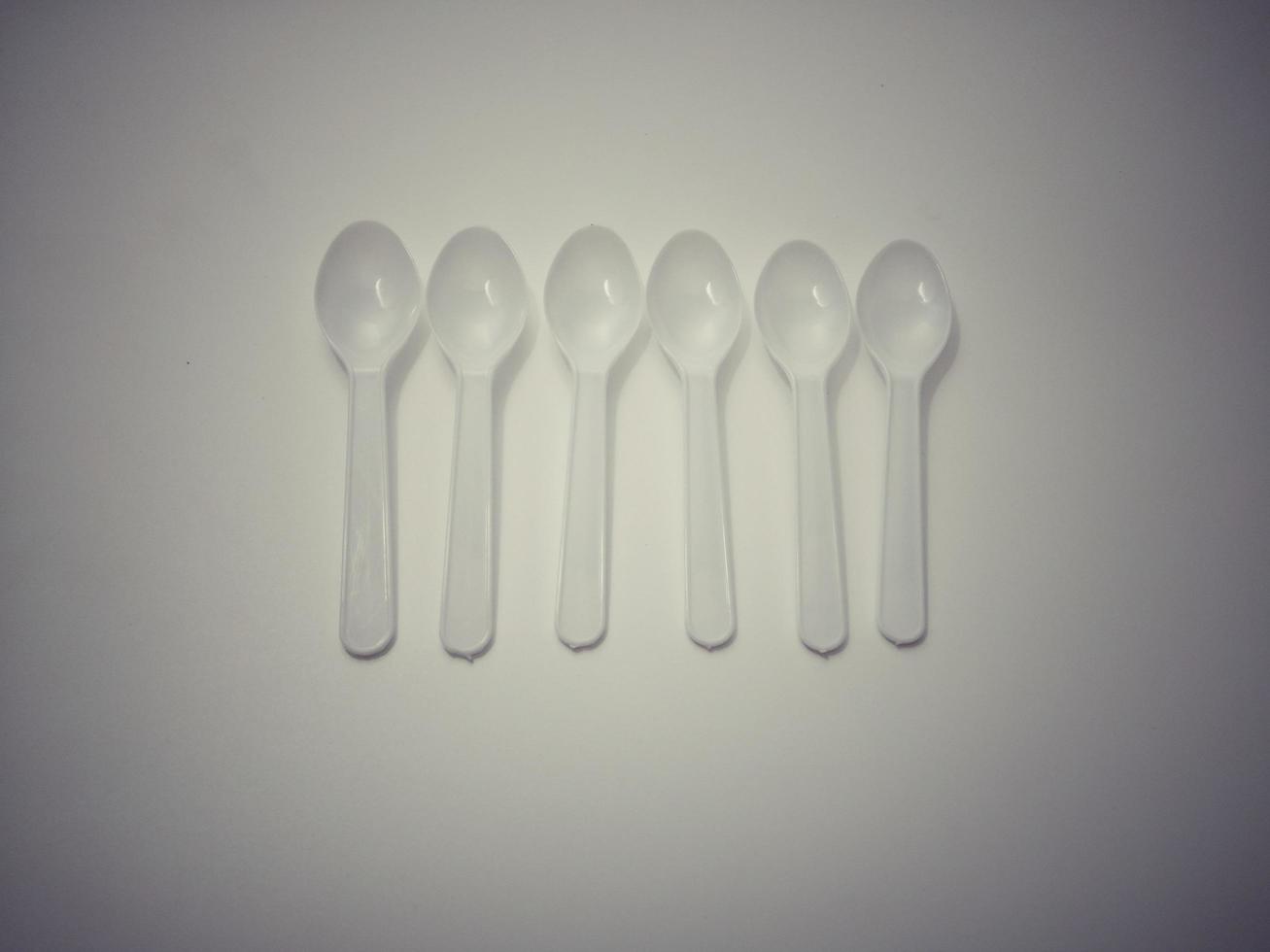 White plastic spoon white background gives the concept of disposable plastic that pollutes the environment.  Affecting global warming photo