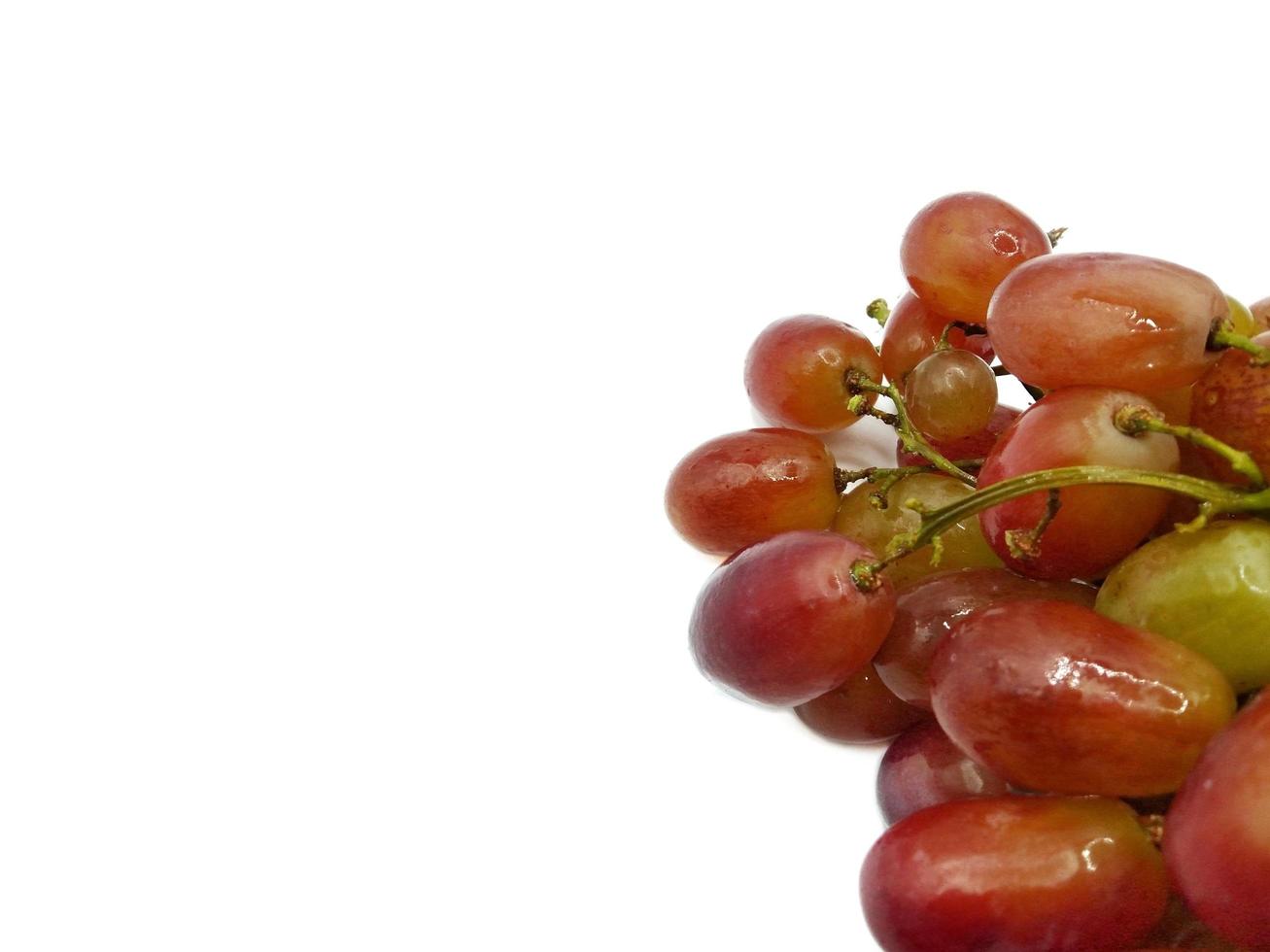 racimo de uvas rojas sobre fondo blanco concepto. el consumo nutritivo de frutas y ayuda en el control de peso. da una sensación agridulce foto