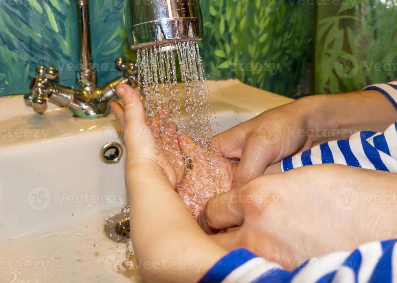 el primer plano de un hombre caucásico y un niño se lava las manos en el baño. covid-19 prevención foto