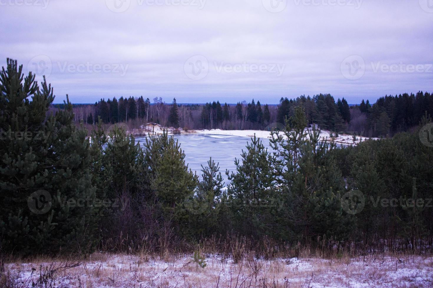 Summer landscape with a beautiful lake with fir trees and forested mountains against a cloudy sky photo