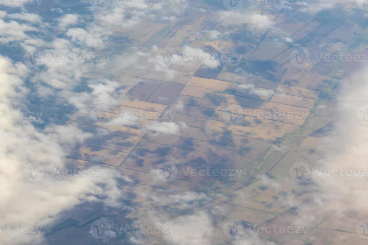 Aerial photo of Farmland. view from the plane to the ground. squares of fields under the clouds