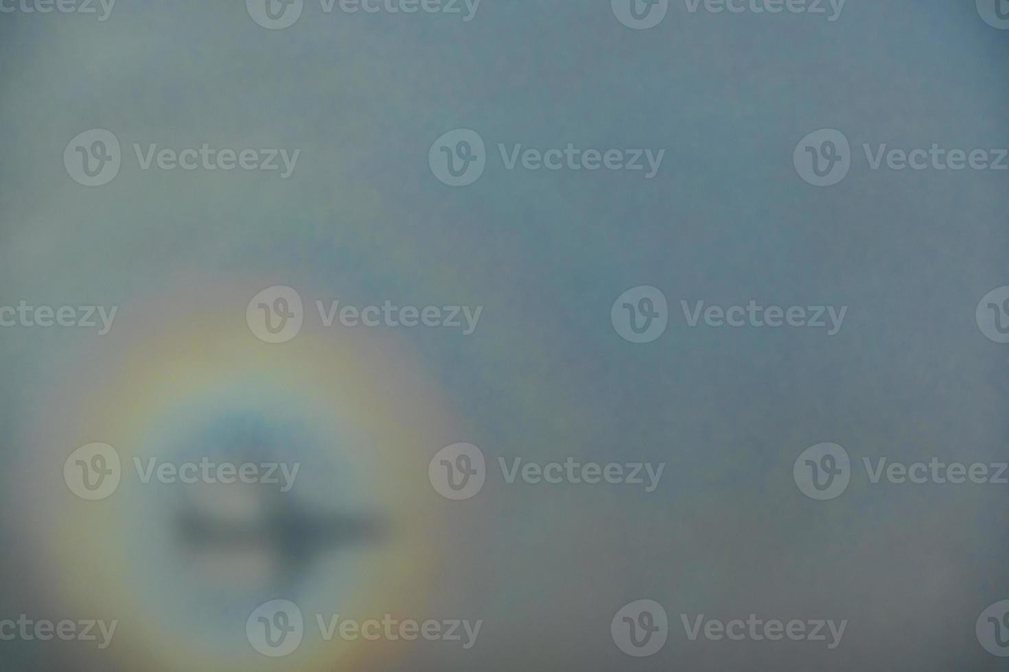 blurry shadow of the airplane on the cloud with the rainbow circle. traveling concept photo