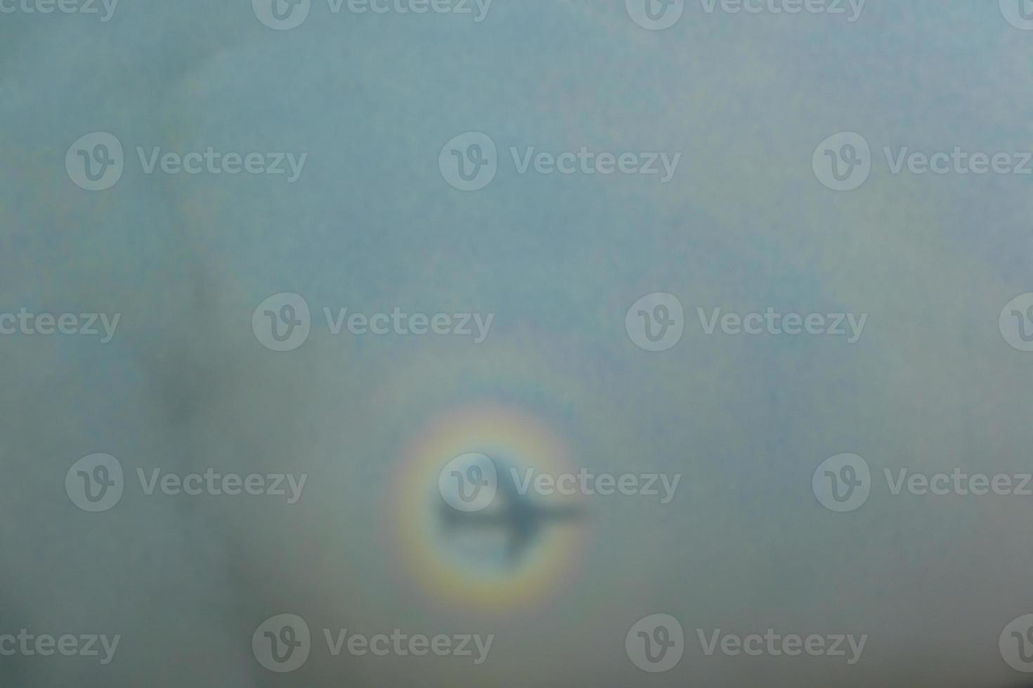 blurry shadow of the airplane on the cloud with the rainbow circle. traveling concept photo