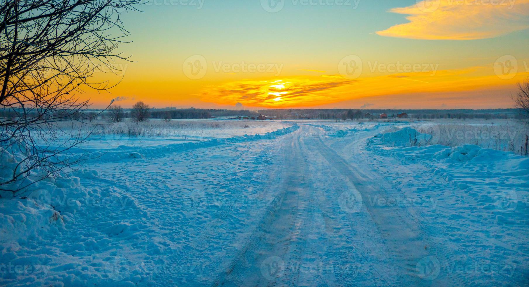 The beautiful sunset with tracks in snow winter background photo