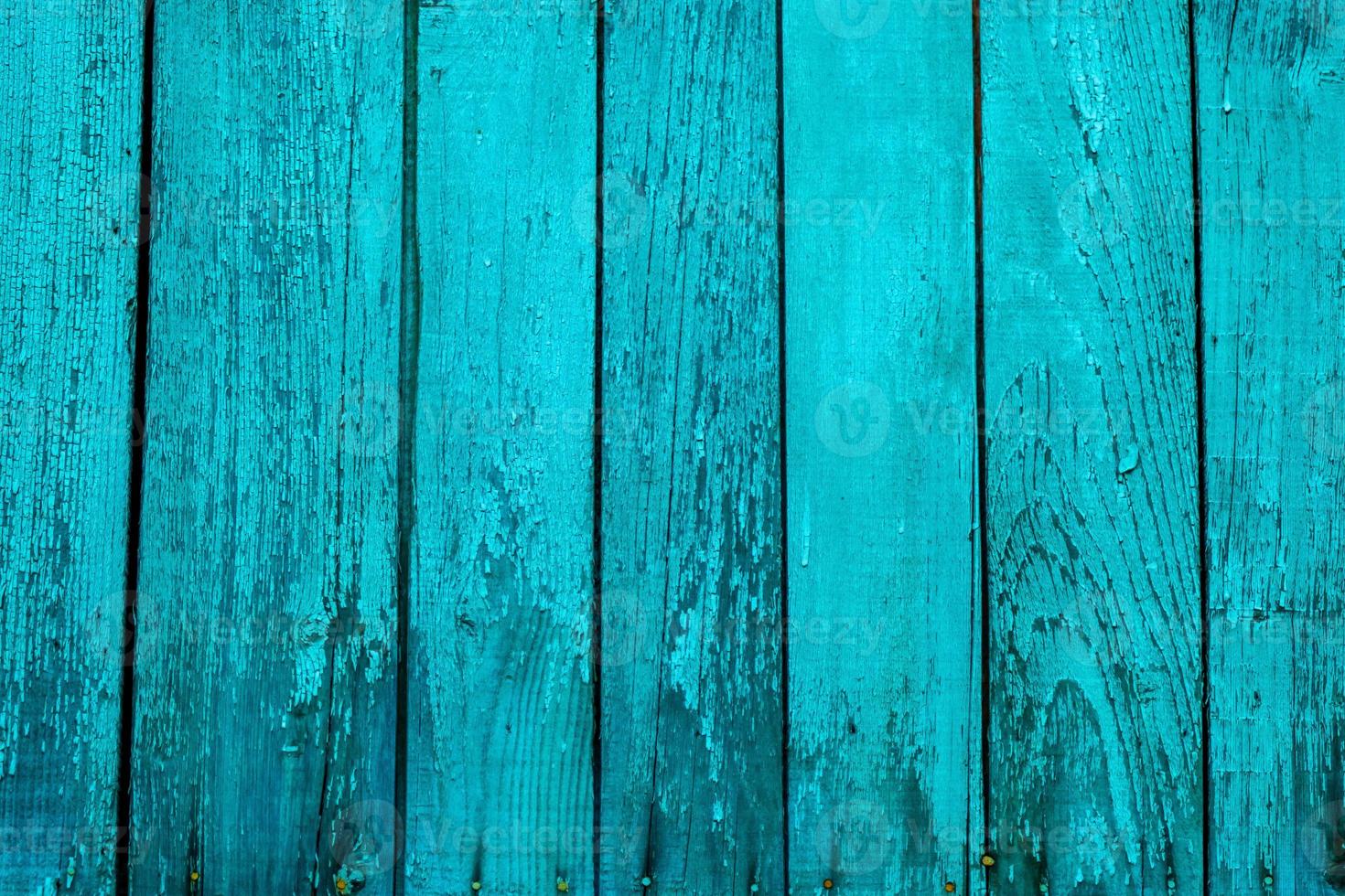 Close up of scratched turquoisewooden texture of a fence. Blue or green wooden planks photo