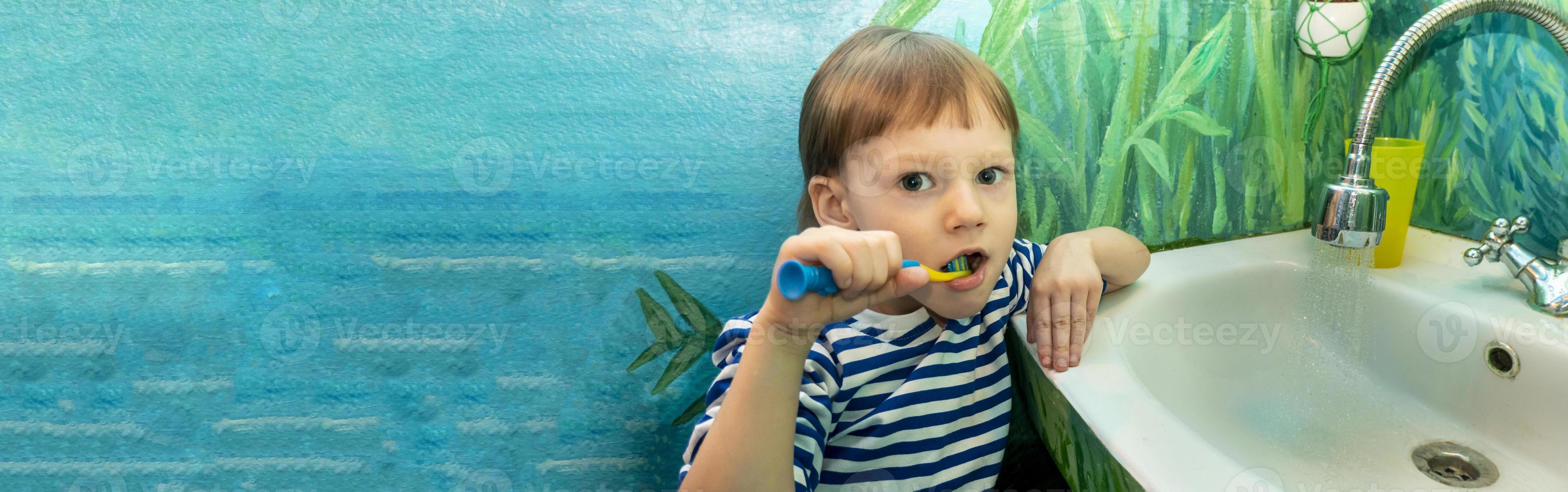 Close up of young boy brushing teeth in the dentists chair photo