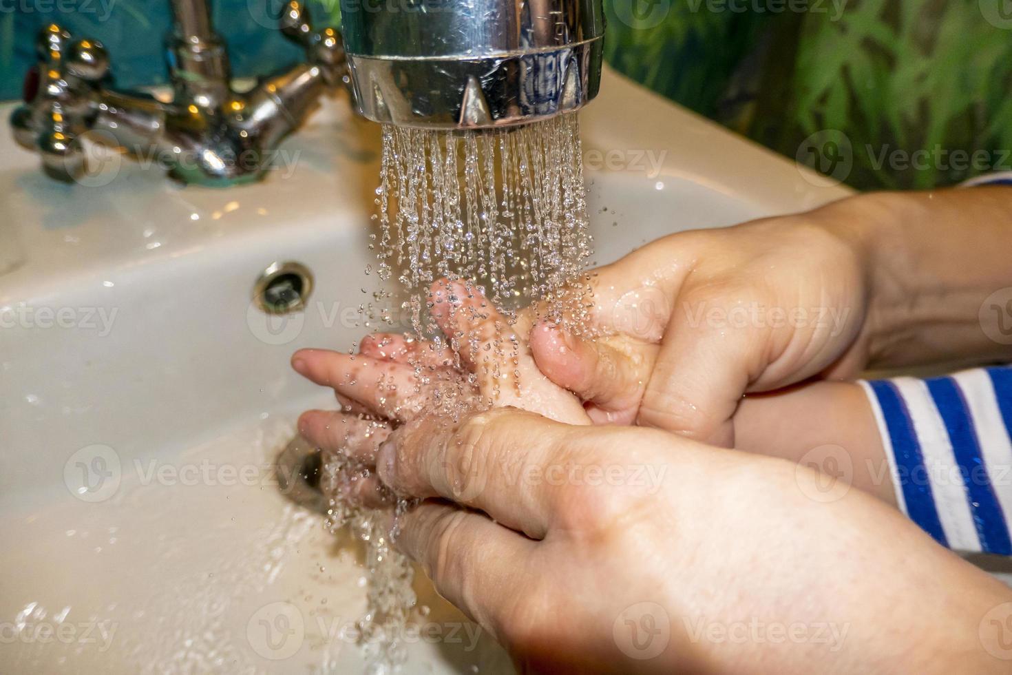 el primer plano de un hombre caucásico y un niño se lava las manos en el baño. covid-19 prevención foto