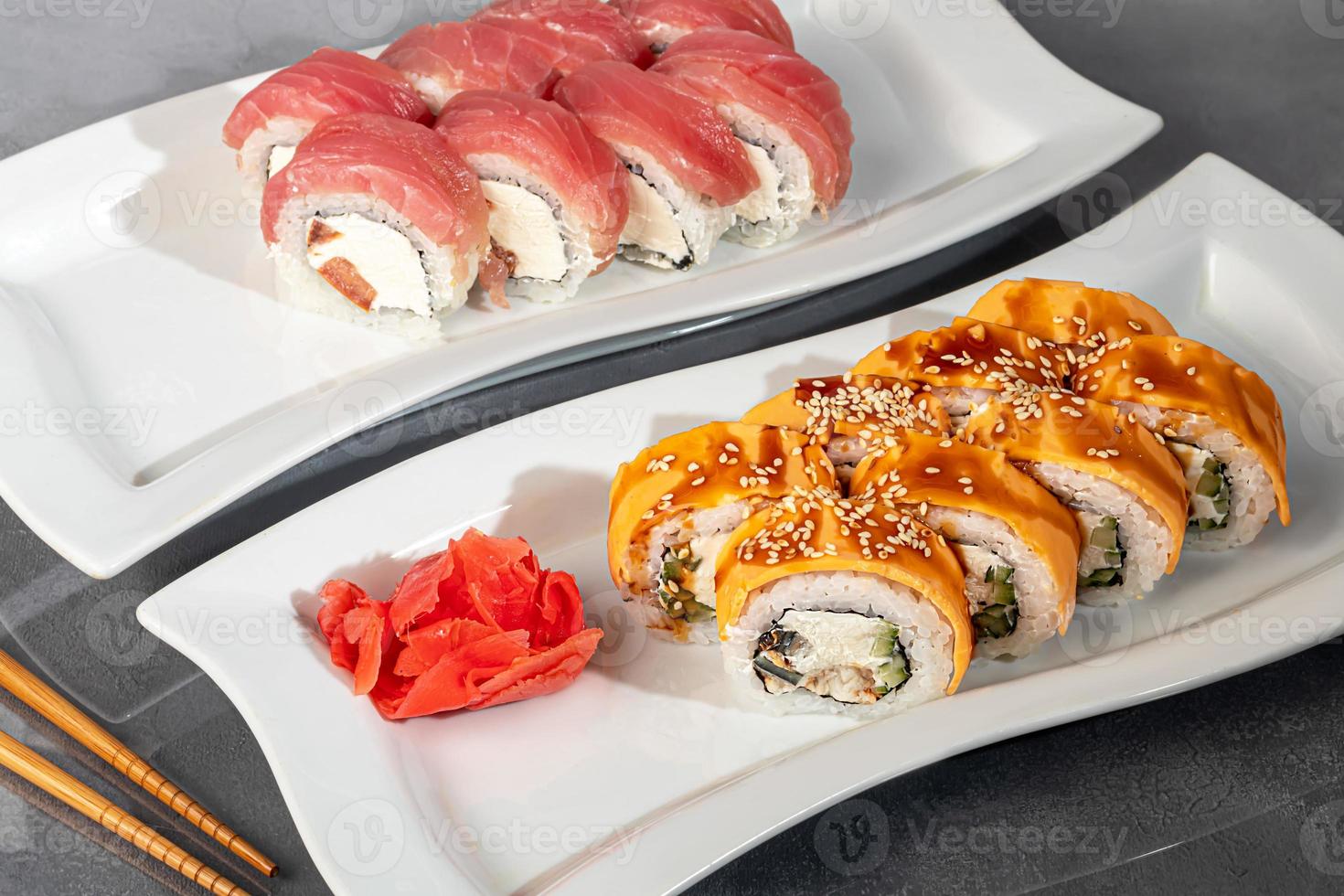Sushi sets Uramaki, California, Philadelphia, rolls on a white plate. Menu for restaurants, cafes. On a dark reflective background. photo