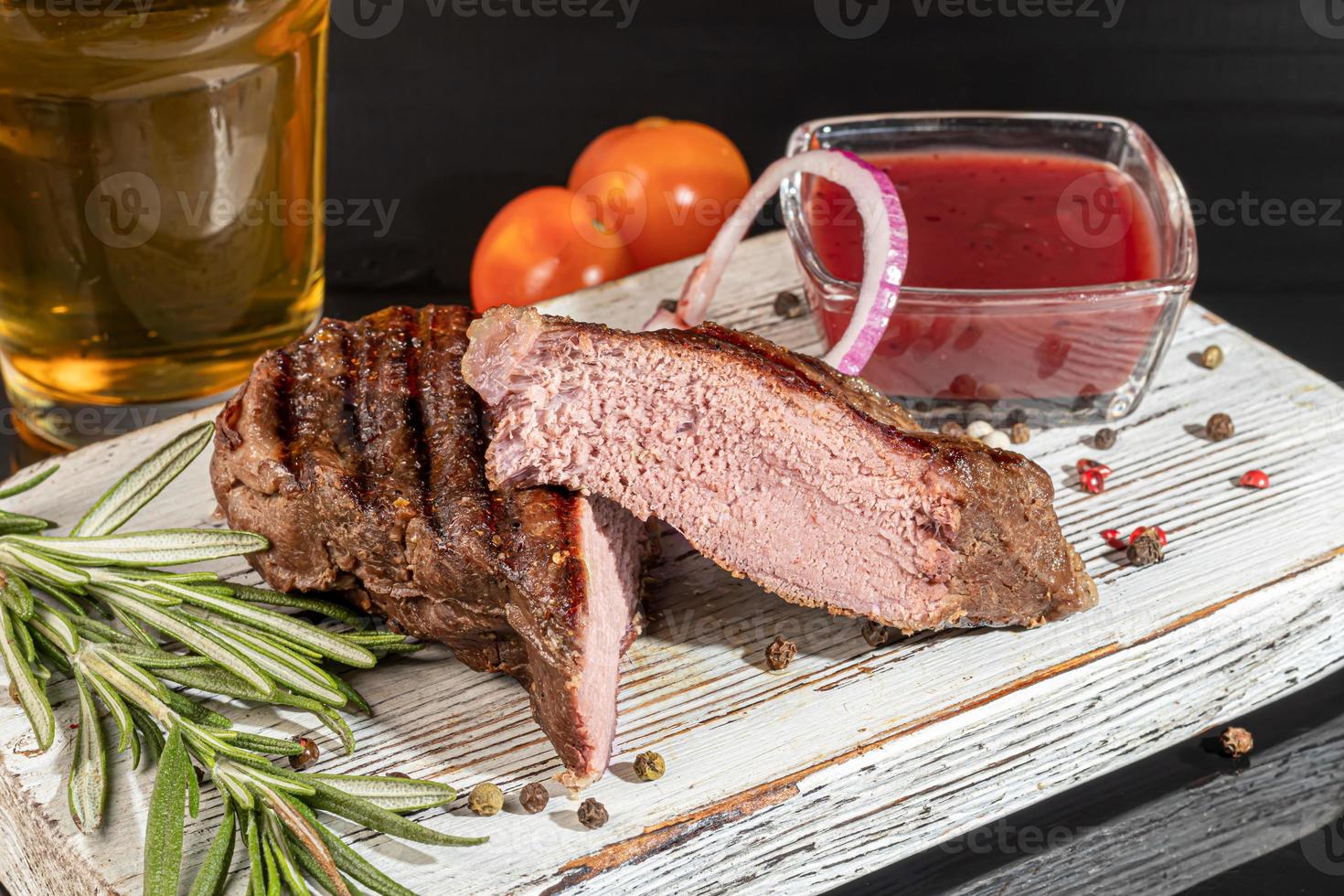 plato de carne en un plato con salsa. pechuga de pollo, cerdo frito. perejil. salsas de mostaza y ketchup. sobre un fondo oscuro. foto