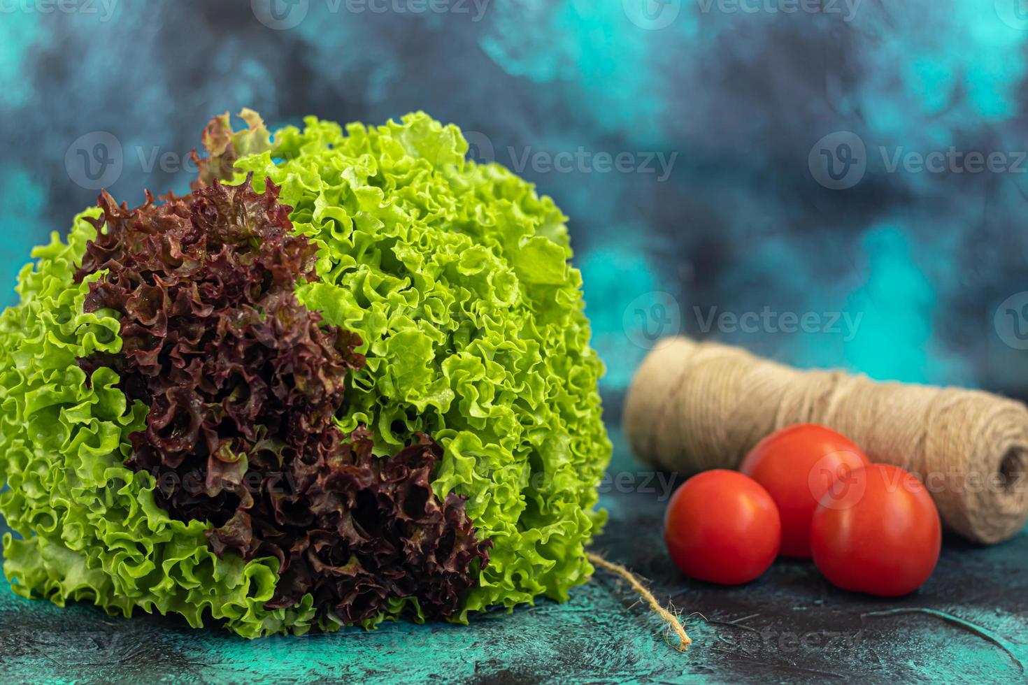 hojas de lechuga verde y roja. cosecha de primavera, beneficios y vitaminas. sobre un fondo oscuro. foto