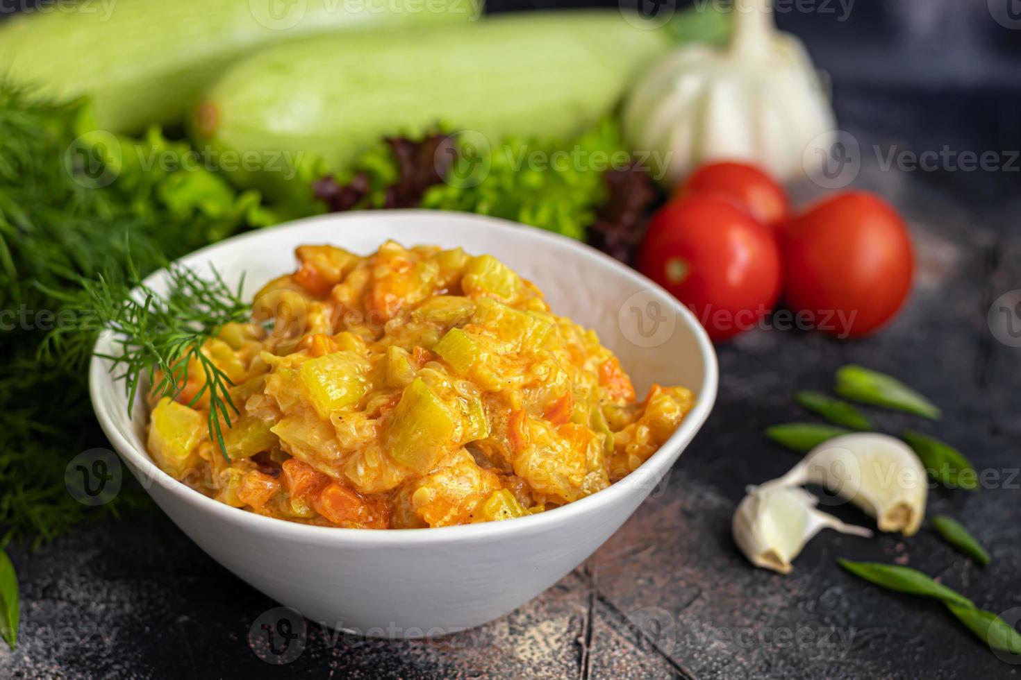 Caviar from zucchini, carrots and onions. Spring food. Vegetarianism. Along with spring vegetables. On a dark background. photo