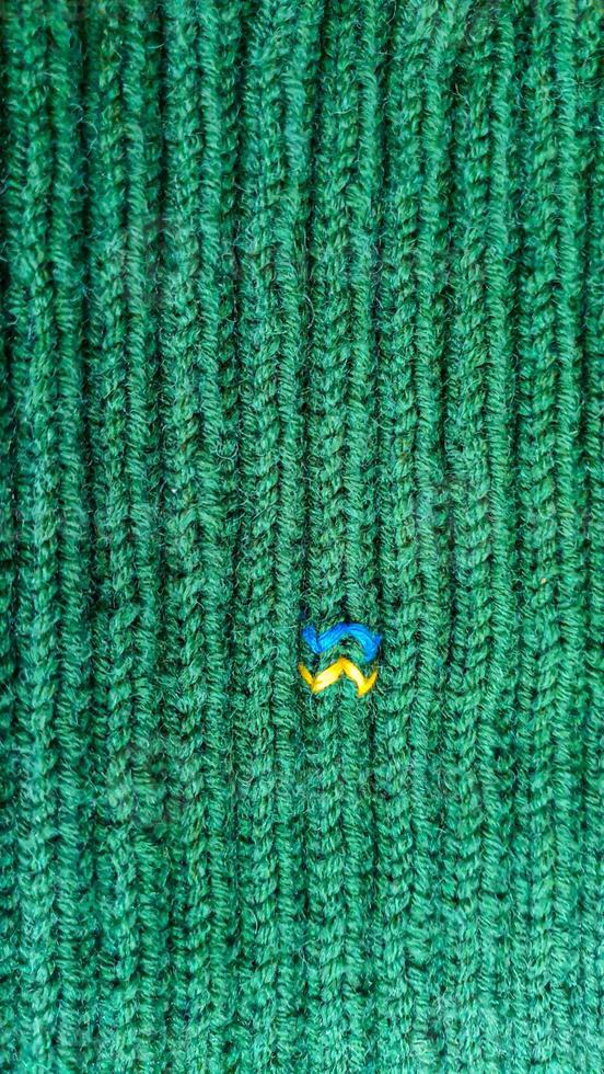 Handmade balaclava with Ukrainian symbols. Knitted from gray and green threads. Warms, reliably saves from the cold. photo