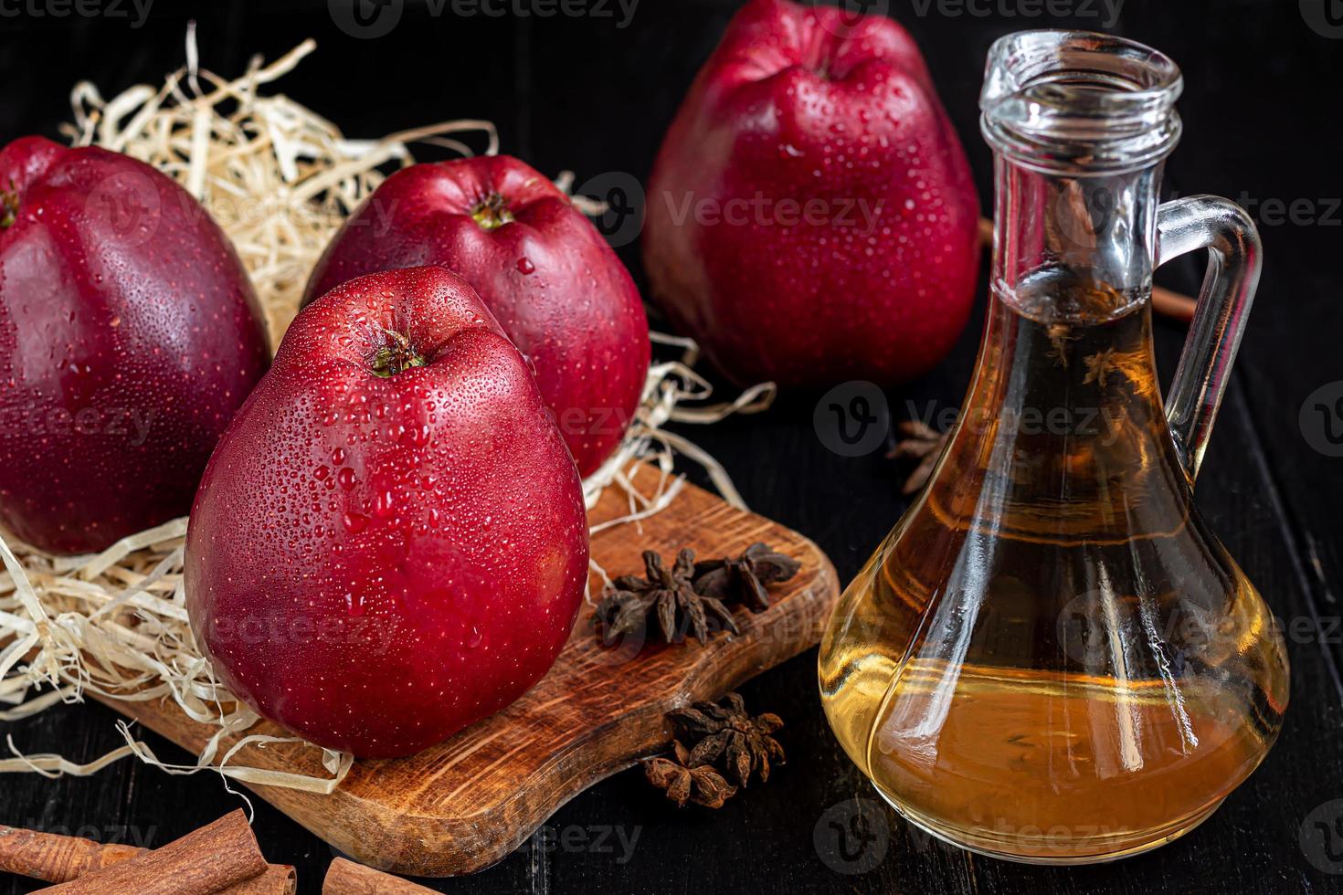 vinagre de sidra de manzana y manzanas rojas sobre un fondo oscuro de madera. enfoque selectivo. producto fermentado. comida sana. foto