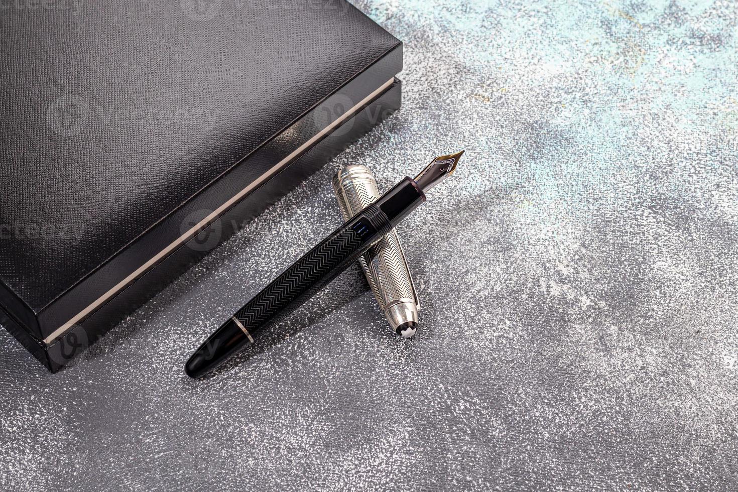 Fountain pen on a marble and gray background. Selective focus. photo