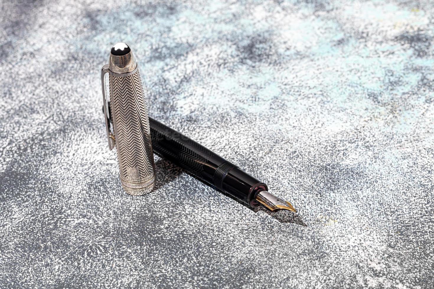 Fountain pen on a marble and gray background. Selective focus. photo