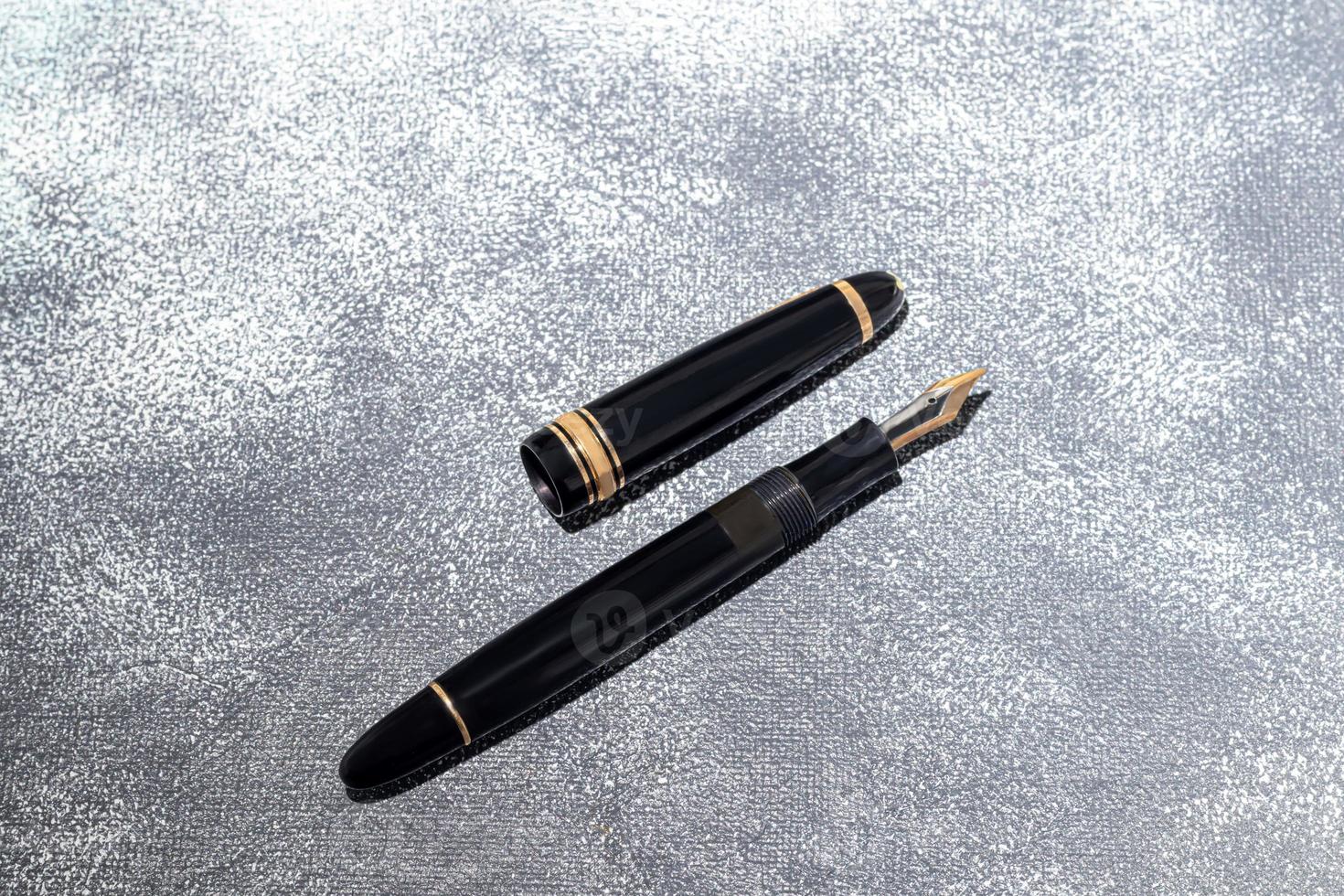 Fountain pen on a marble and gray background. Selective focus. photo