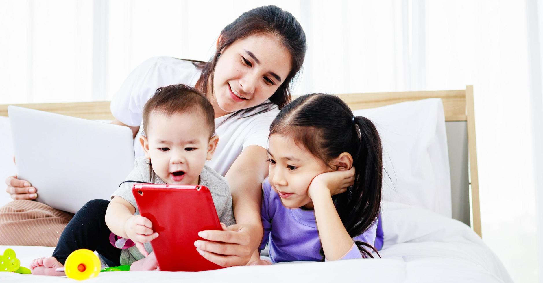 Busy single mom working from home and caring for her baby and little daughter photo