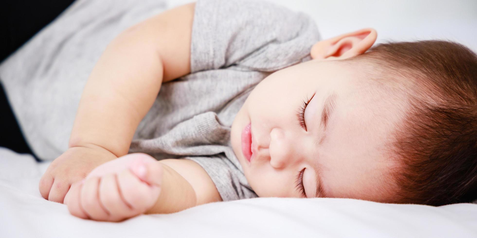 newborn sleeping baby in bed. Modern motherhood, banner size photo