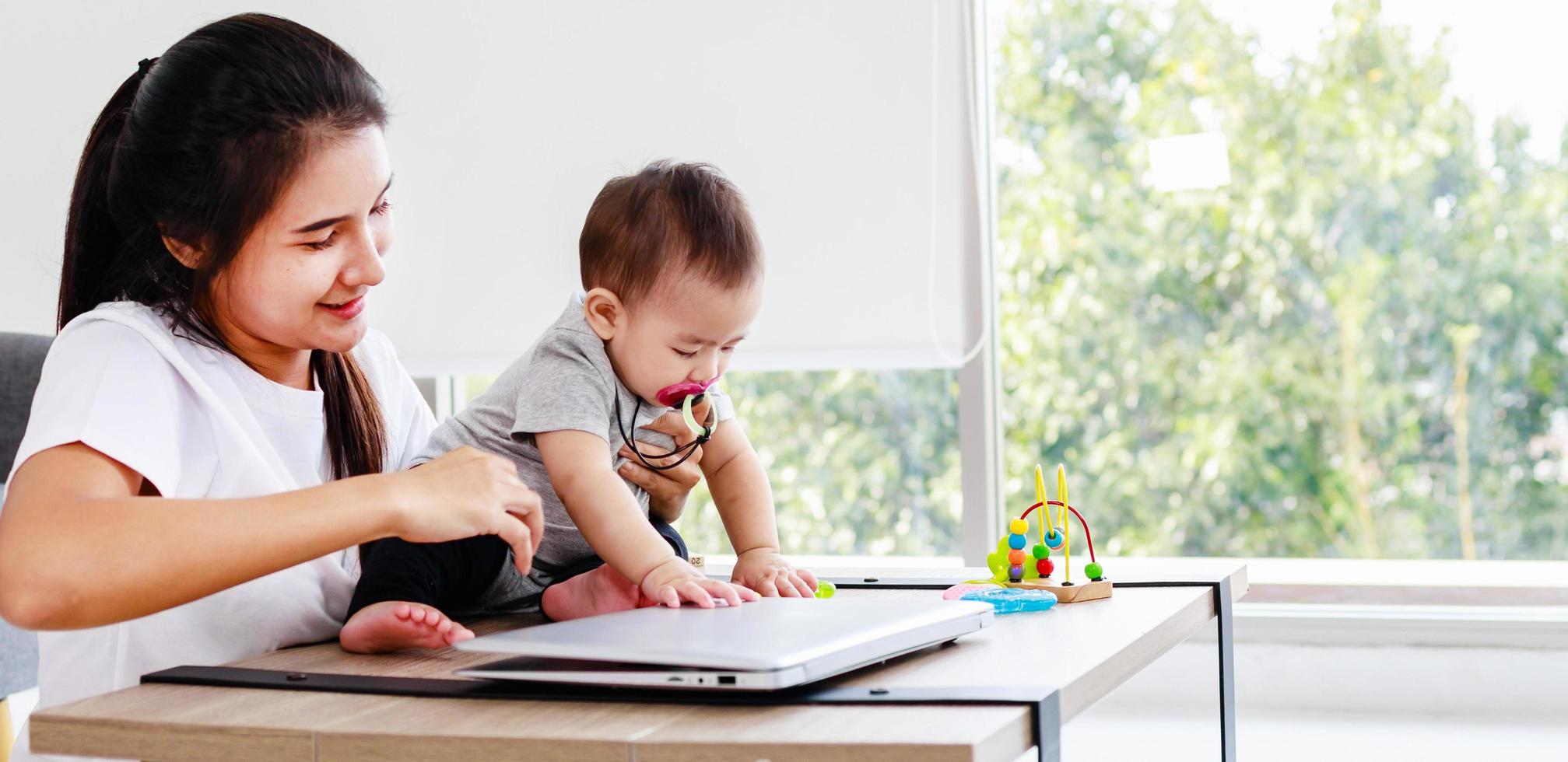 Mother freelance work at home. Modern motherhood, little baby girl. online education of children photo
