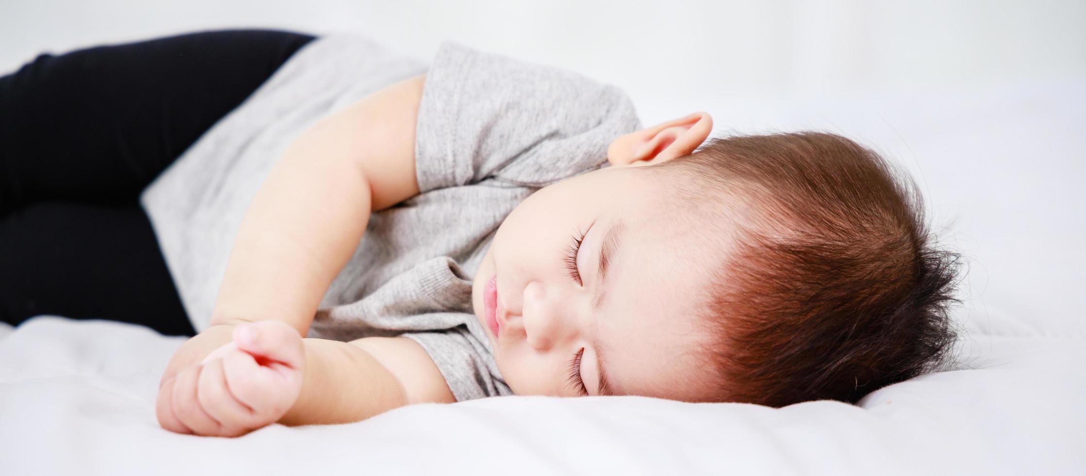 newborn sleeping baby in bed. Modern motherhood photo