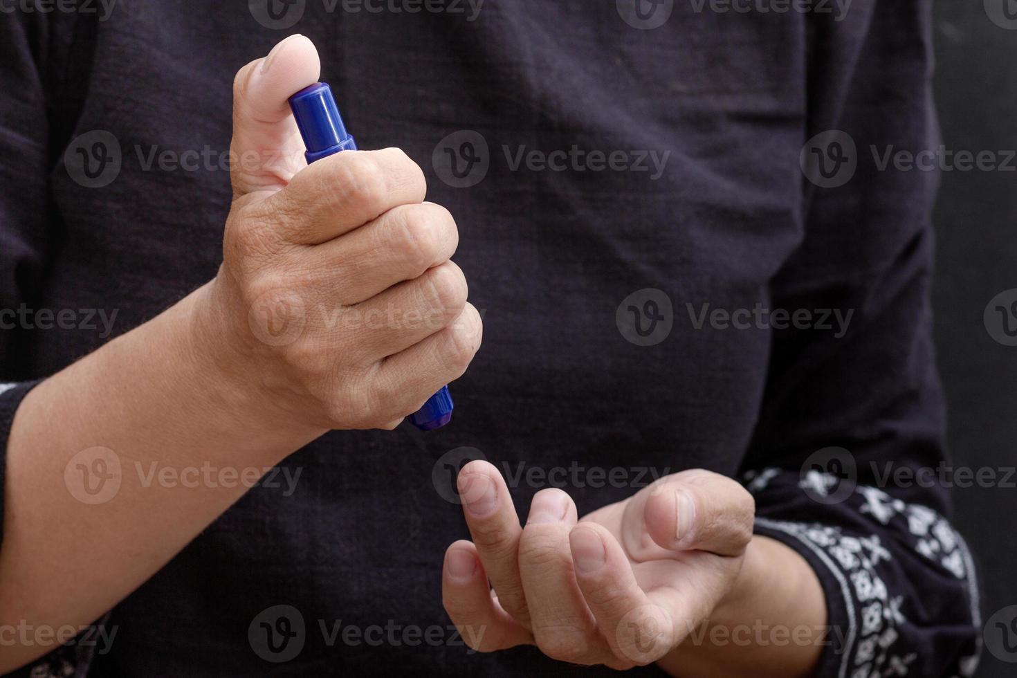 Woman hands holding lancet to prick finger to check sugar in blood photo