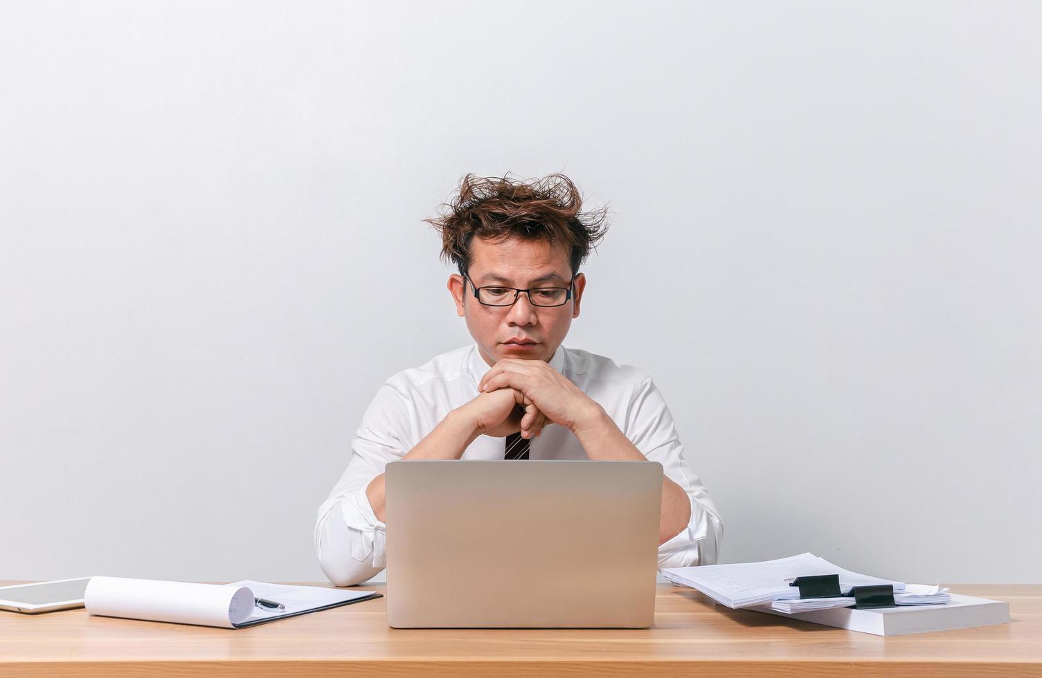 hombre de negocios asiático sentado y trabajando y estresado foto