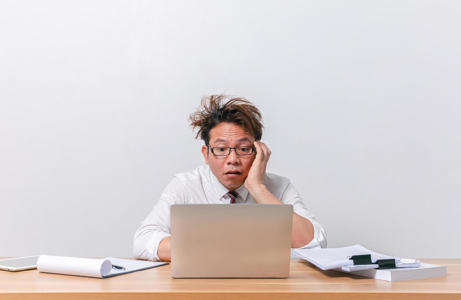 hombre de negocios asiático sentado y trabajando y estresado foto