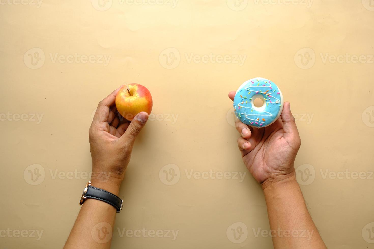 hand holding donuts and apple on hand on blue background photo