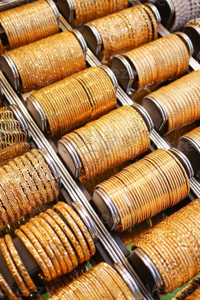 golden color bangles display for sale at local store , photo