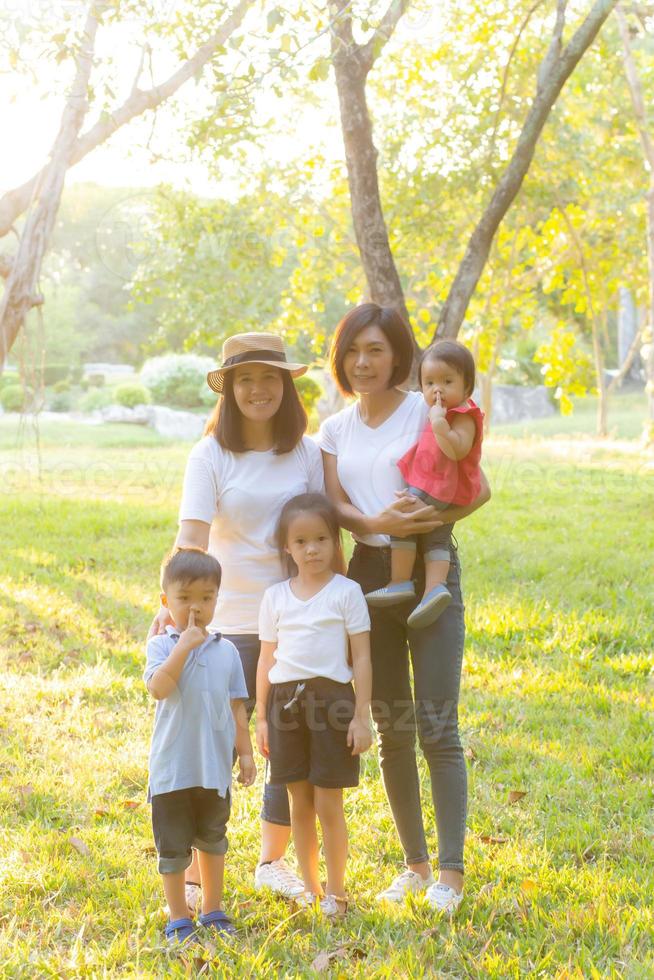 Beautiful young asian parent family portrait picnic in the park, kid or children and mother love happy and cheerful together in summer at garden, lifestyle concept. photo