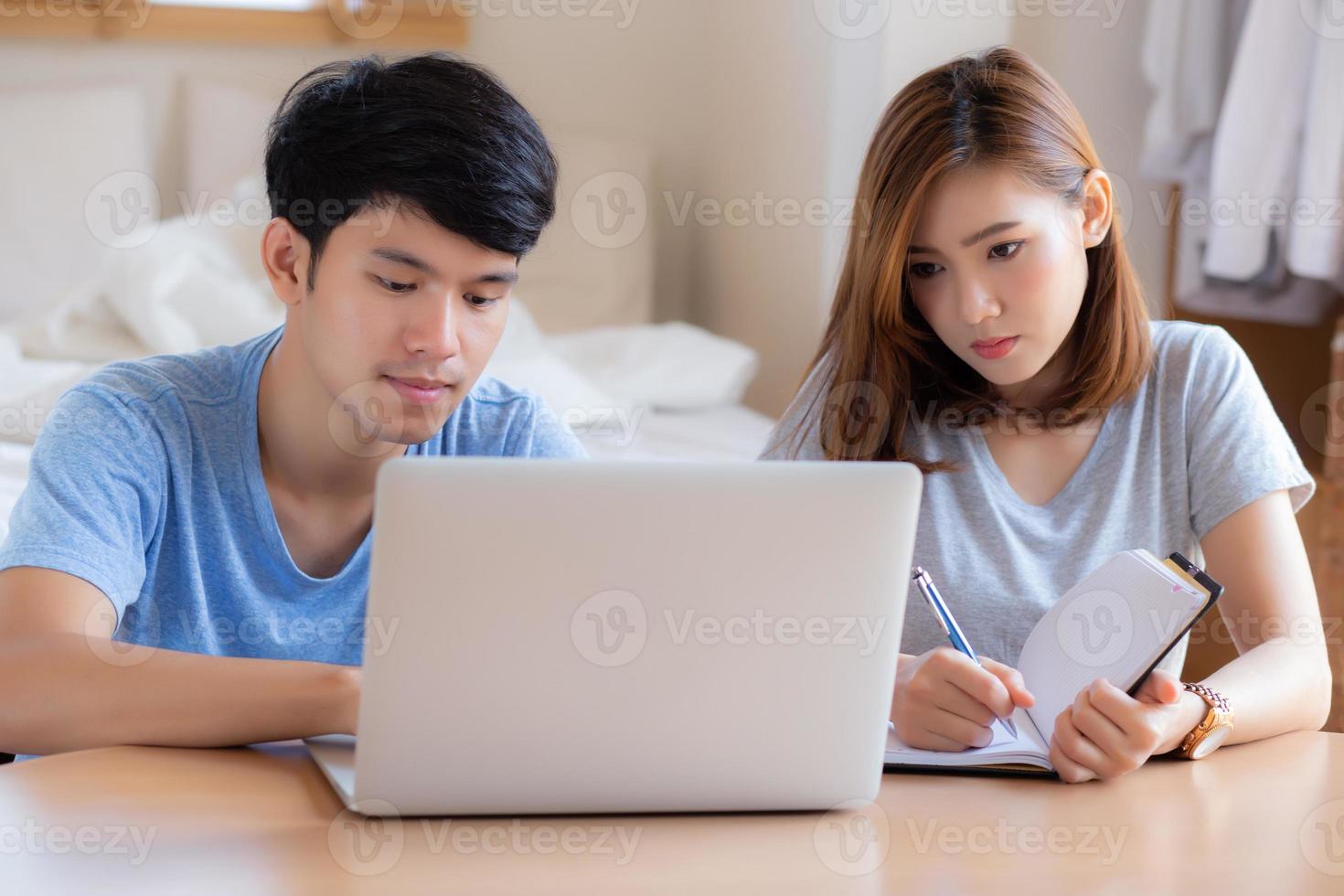 Beautiful young asian couple calculate expenses finance with laptop and planning together, woman writing notebook or note budget household, lifestyle family and business concept. photo