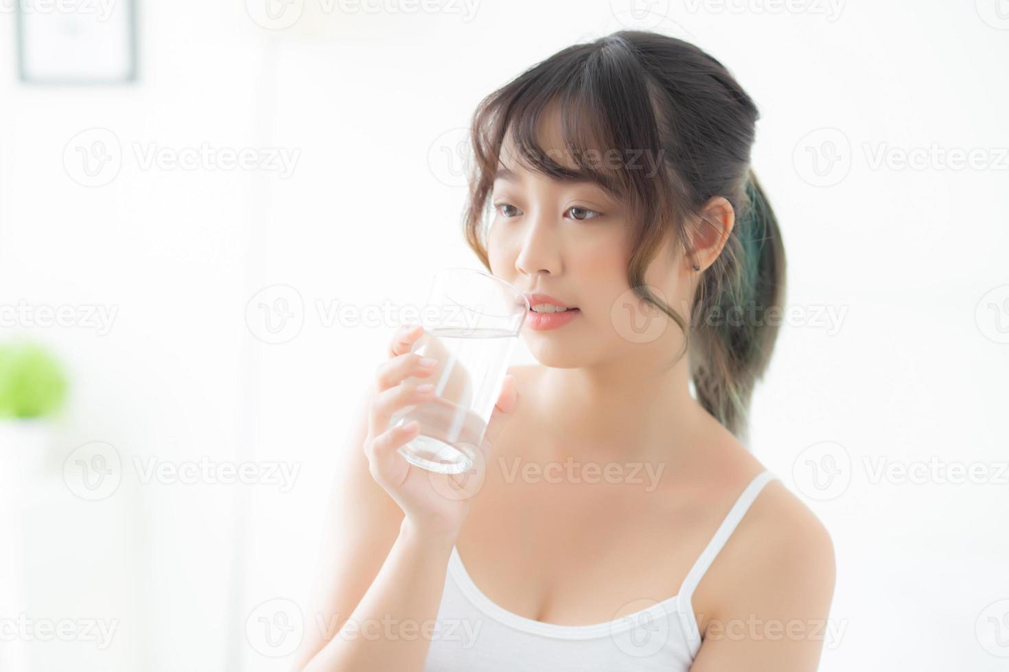 Beautiful portrait young asian woman caucasian smiling with nutrition thirsty and drinking glass of water mineral with fresh and happy, asia girl diet for healthy care and wellness, lifestyle concept. photo