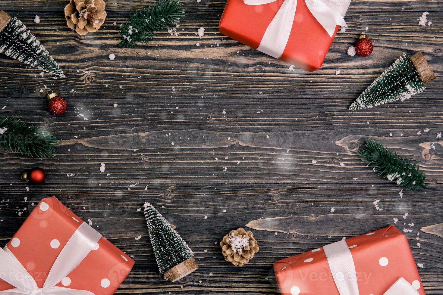 composición navideña con caja de regalo roja y decoración de etiquetas sobre fondo de madera, año nuevo y navidad o aniversario con regalos sobre mesa de madera en temporada, vista superior o puesta plana. foto