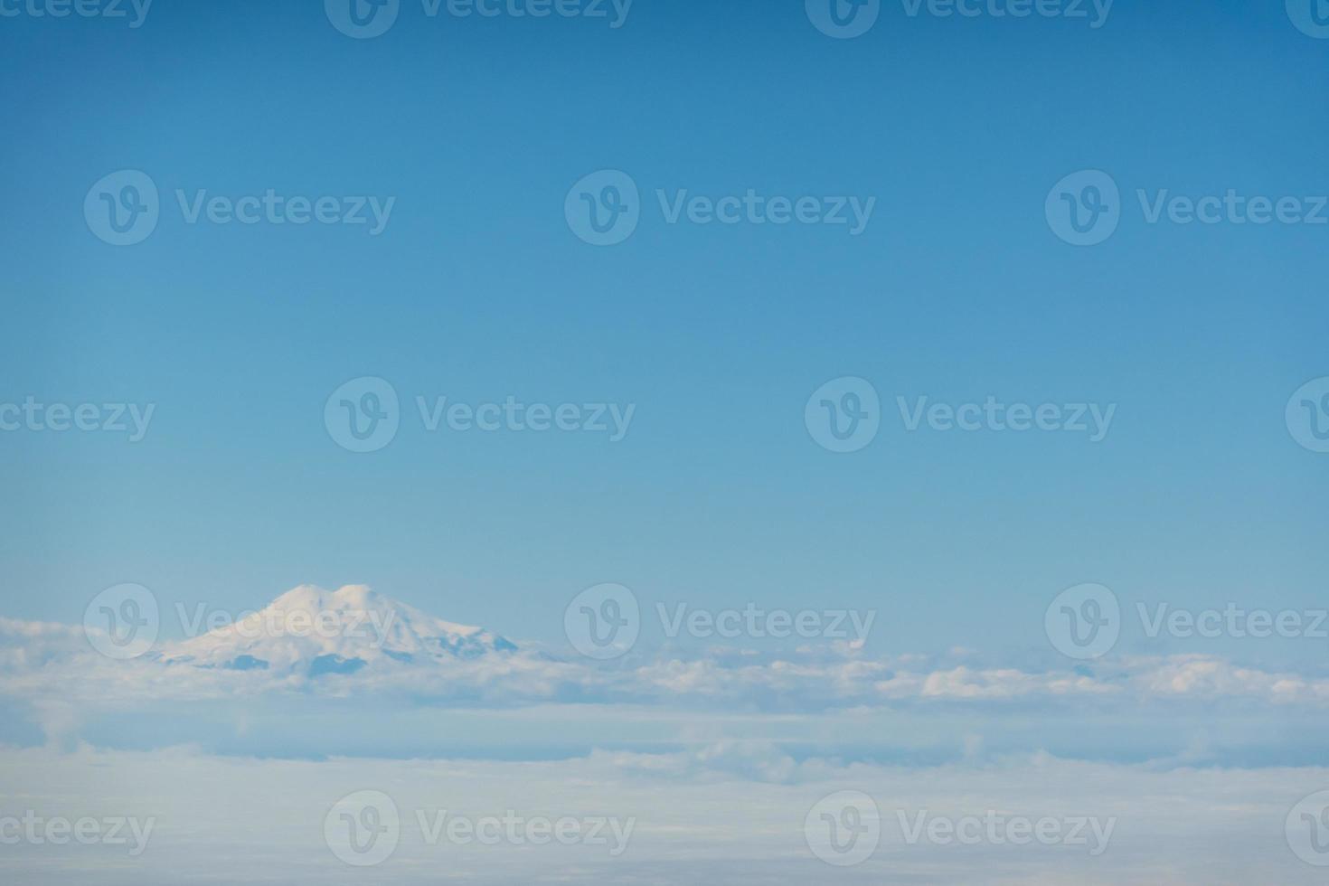 Aerial view over Elbrus, Karachay Cherkessia. elbrus shines through the clouds photo