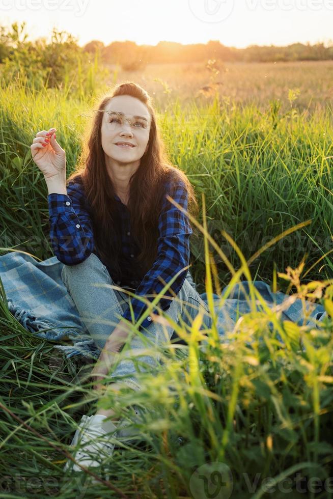 Portrait of a beautiful young woman on meadow photo