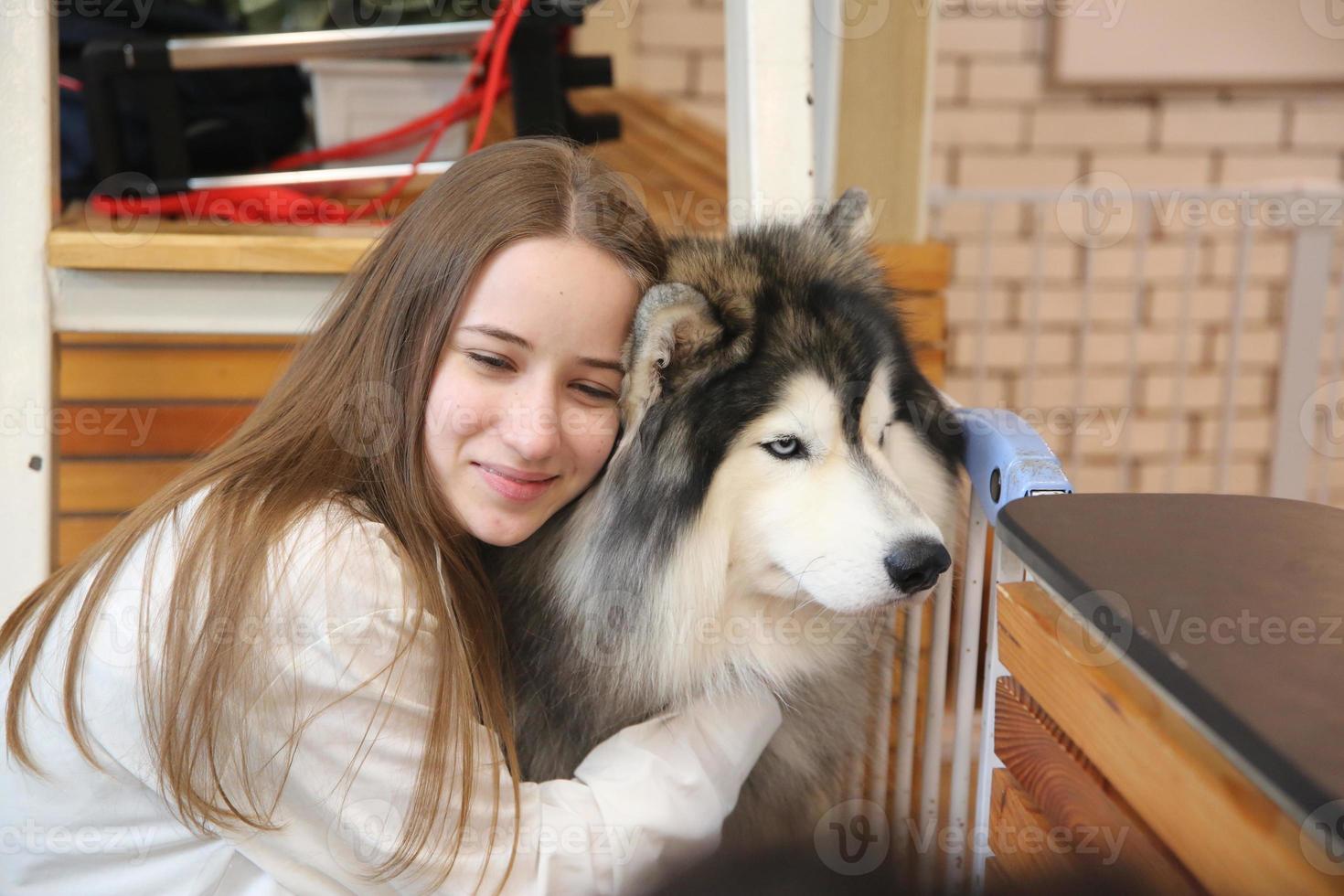 Girl Pet owner hugging with dog puppy. Happy Human female and cute funny dog lying on floor together photo