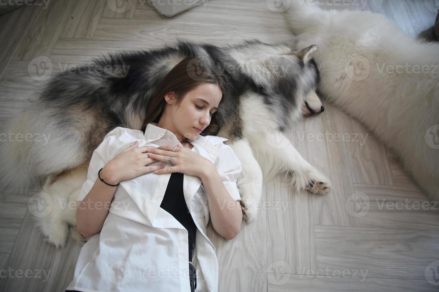 dueña de una mascota abrazándose con un cachorro de perro. feliz mujer humana y lindo perro divertido tirados en el suelo juntos foto