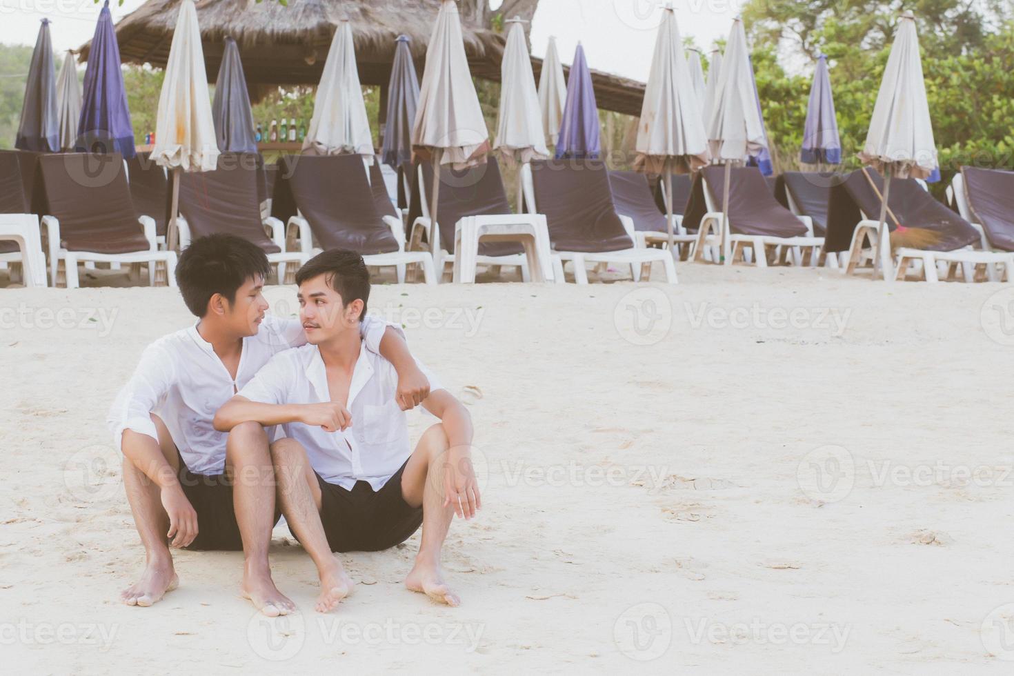 Homosexual portrait young asian couple sitting hug together on beach in summer, asia gay going tourism for leisure and relax with romantic and happiness in vacation at sea, LGBT legal concept. photo