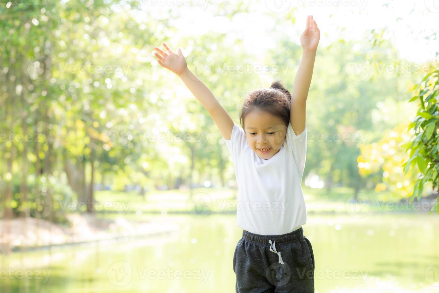 Beautiful young asian child smiling and cheerful playing at park, asia kid confident jump and fun in the garden activities outdoor at garden in nature summer, lifestyle concept. photo